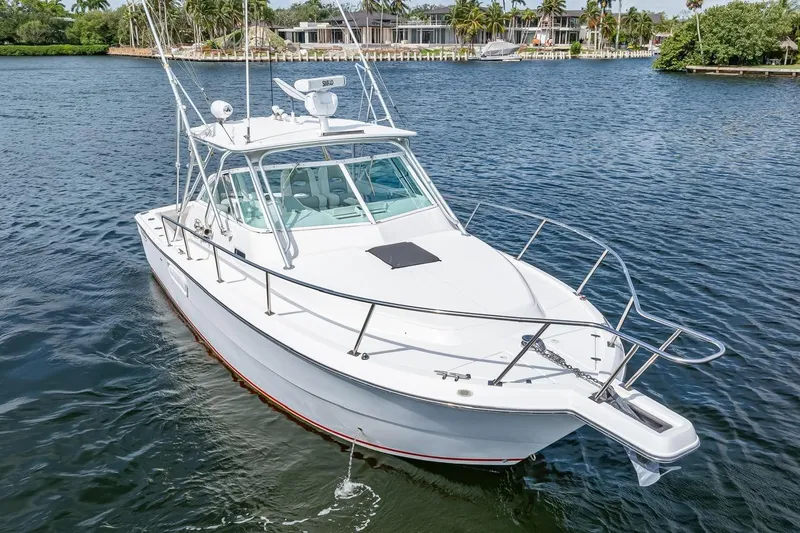 Slide: The Image of 2000 Rampage 30 Express boat on calm water, featuring sleek design and fishing equipment. - 6