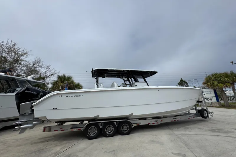 Slide: The Image of 2026 Invincible 38 Catamaran on trailer, sleek design, outdoor setting. - 10