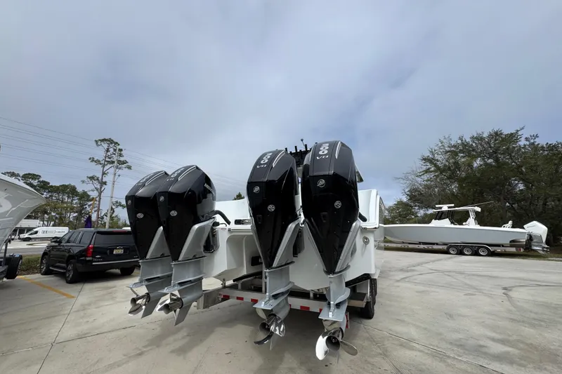 Slide: The Image of 2026 Invincible 38 Catamaran with quad outboard engines in a parking lot. - 13