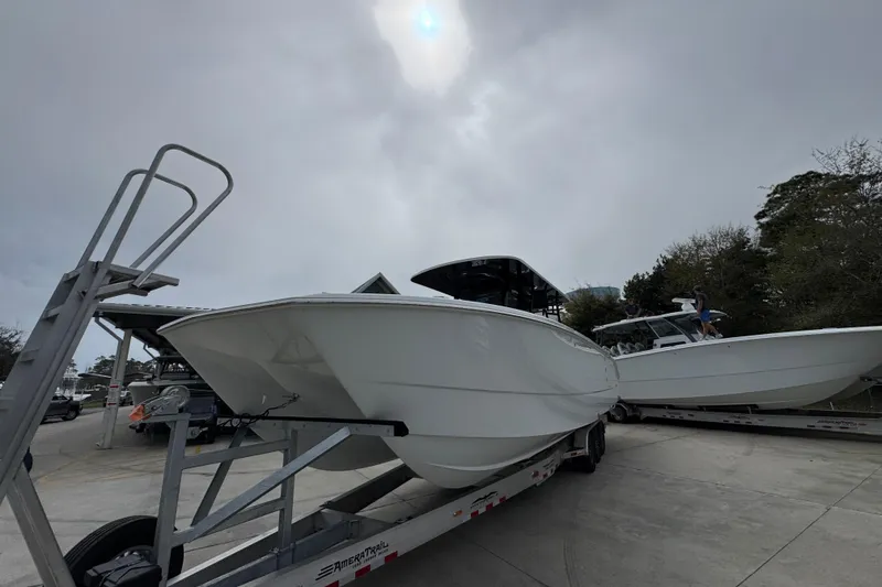 Slide: The Image of 2026 Invincible 38 Catamaran on trailer under cloudy sky, ready for transport. - 3