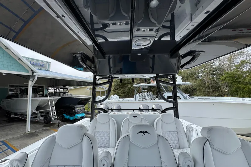 Slide: The Image of 2026 Invincible 38 Catamaran with luxurious seating and sleek design at a marina. - 31