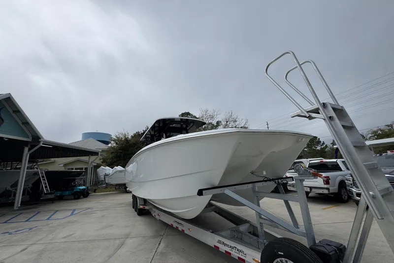 Slide: The Image of 2026 Invincible 38 Catamaran on trailer, parked outdoors under cloudy sky. - 6