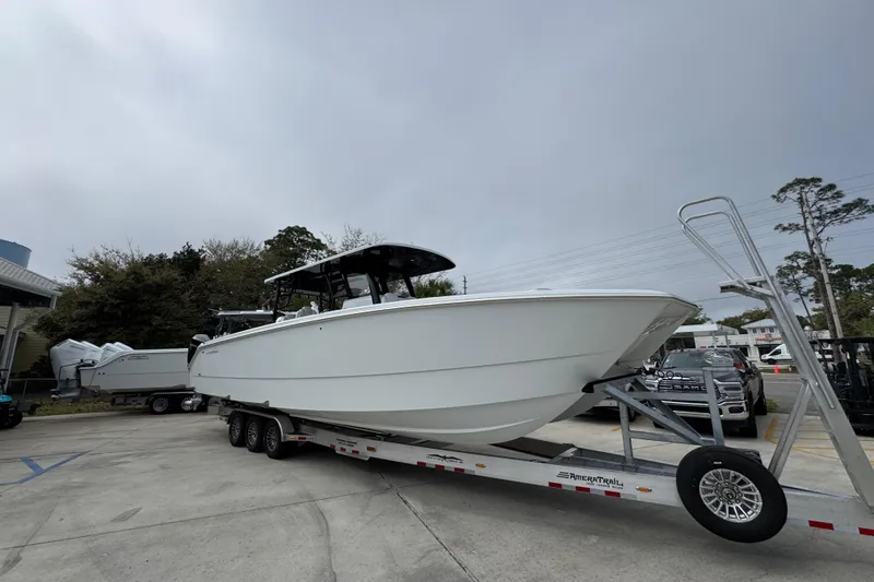 Slide: The Image of 2026 Invincible 38 Catamaran on trailer, parked outdoors under cloudy sky. - 7