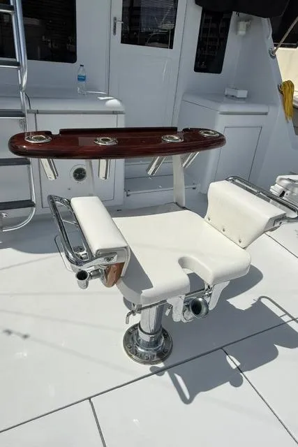 Slide: The Image of Fishing chair on 2002 Hatteras 55 Convertible yacht deck, featuring rod holders and white upholstery. - 16