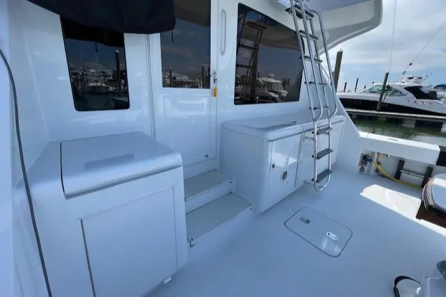 Slide: The Image of 2002 Hatteras 55 Convertible yacht deck with ladder and storage compartments. - 18