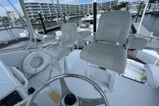 Slide: The Image of 2002 Hatteras 55 Convertible yacht helm with two captain's chairs, marina view. - 23