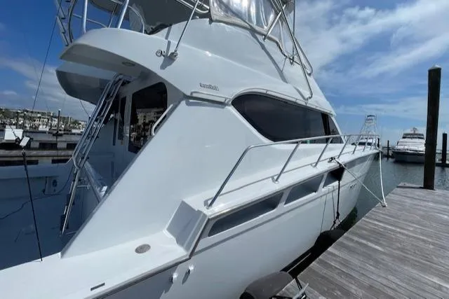 Slide: The Image of 2002 Hatteras 55 Convertible yacht docked at marina under blue sky. - 3