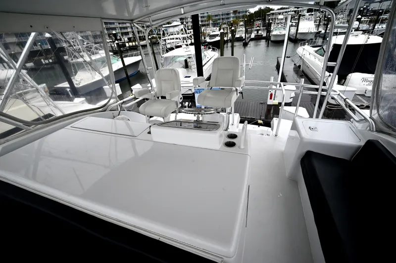 Slide: The Image of 2002 Hatteras 55 Convertible yacht interior with helm chairs and marina view. - 30