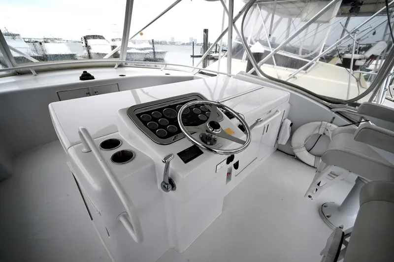 Slide: The Image of 2002 Hatteras 55 Convertible yacht helm with steering wheel and controls, docked at marina. - 32