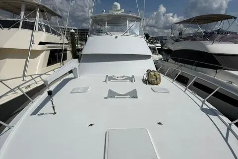 Slide: The Image of 2002 Hatteras 55 Convertible yacht docked between two boats. - 39