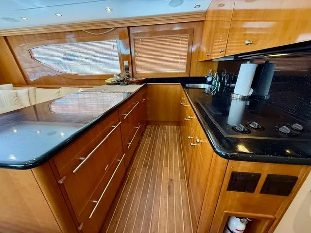 Slide: The Image of Luxurious kitchen interior of 2002 Hatteras 55 Convertible yacht with wood cabinetry and modern appliances. - 55
