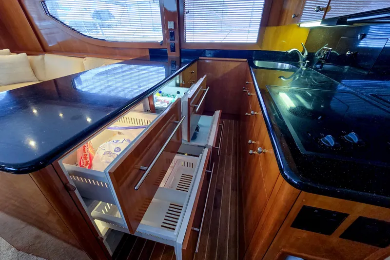 Slide: The Image of Luxurious kitchen interior of 2002 Hatteras 55 Convertible yacht with open drawers. - 56