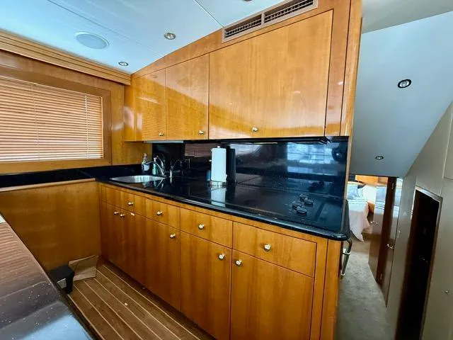 Slide: The Image of Luxurious kitchen interior of 2002 Hatteras 55 Convertible yacht with wooden cabinetry. - 57