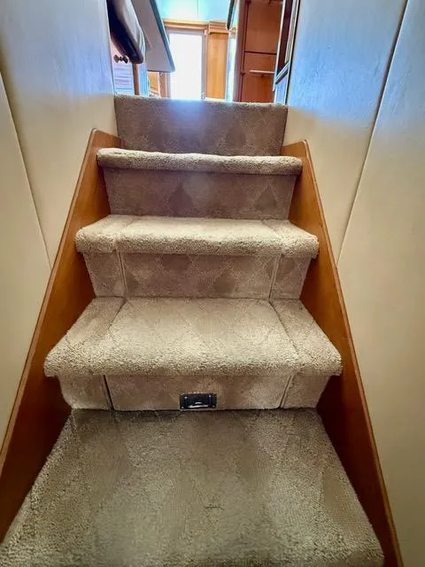 Slide: The Image of Carpeted stairs inside a 2002 Hatteras 55 Convertible yacht. - 59