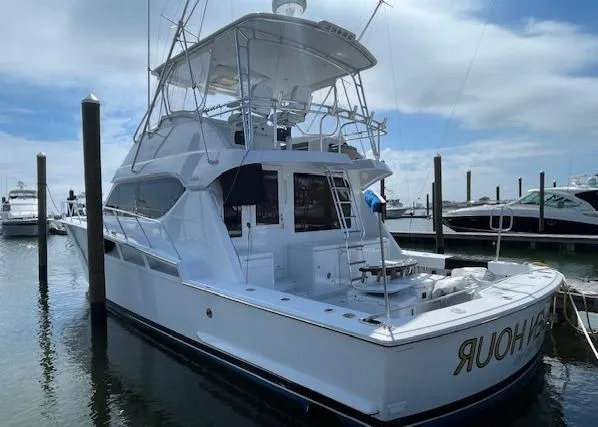 Slide: The Image of 2002 Hatteras 55 Convertible yacht docked at marina under cloudy sky. - 6