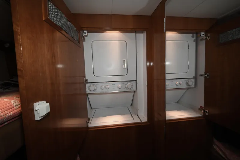 Slide: The Image of Laundry area with stacked washer and dryer in 2002 Hatteras 55 Convertible yacht. - 68