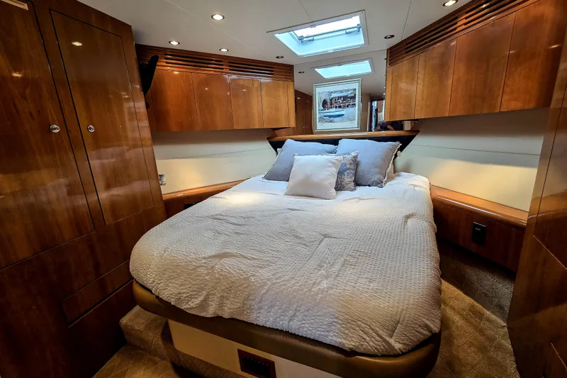 Slide: The Image of Luxurious bedroom interior of 2002 Hatteras 55 Convertible yacht with wood paneling and skylight. - 70