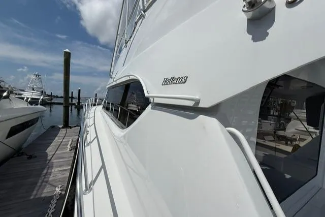 Slide: The Image of 2002 Hatteras 55 Convertible yacht docked at marina under blue sky. - 8