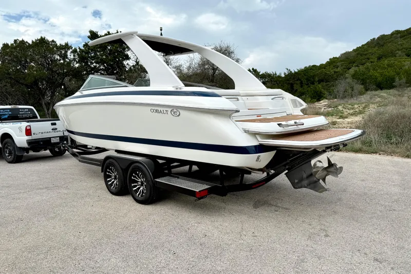 Slide: The Image of 2005 Cobalt 262 boat on trailer, parked outdoors with scenic background. - 12