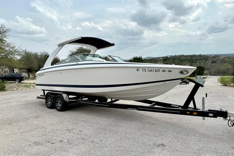 Slide: The Image of 2005 Cobalt 262 boat on trailer, parked outdoors under cloudy sky. - 16