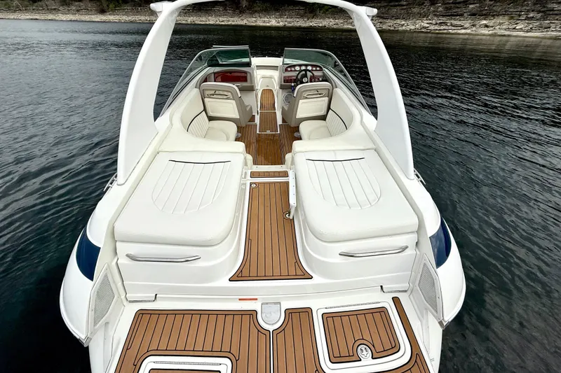 Slide: The Image of 2005 Cobalt 262 boat with white seating and wooden deck on calm water. - 17