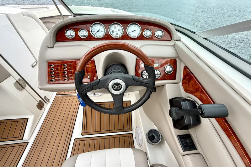 Slide: The Image of Steering console of a 2005 Cobalt 262 boat with wood accents and gauges. - 23