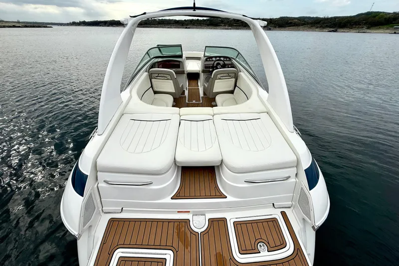 Slide: The Image of 2005 Cobalt 262 boat with white seating and wooden deck on calm water. - 27