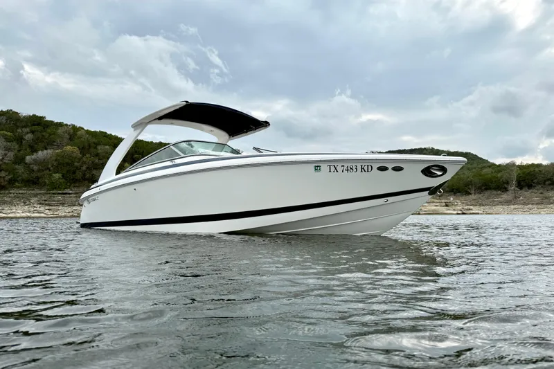 Slide: The Image of 2005 Cobalt 262 boat on water, cloudy sky, and shoreline in the background. - 8