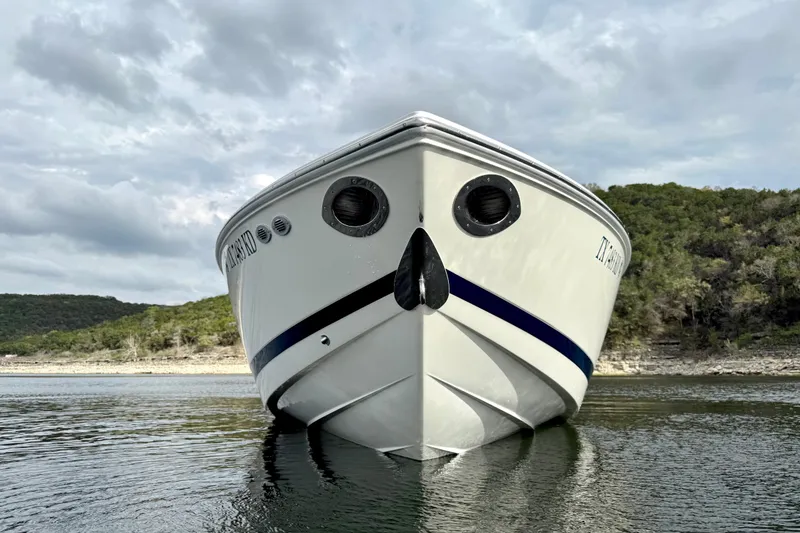Slide: The Image of Front view of a 2005 Cobalt 262 boat on calm water, with a scenic background. - 9