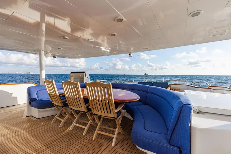 Slide: The Image of Luxury yacht deck with blue sofas and wooden table, ocean view. - 5