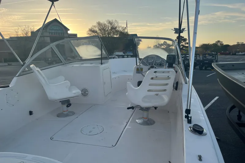 Slide: The Image of 2006 Sea Hunt Escape 175 boat interior with steering wheel and seats at sunset. - 3