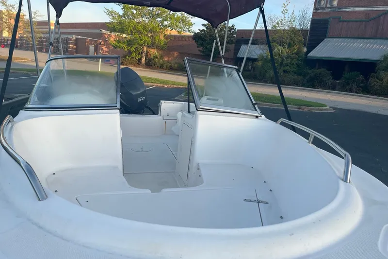 Slide: The Image of 2006 Sea Hunt Escape 175 boat with open deck and windshield in a parking lot. - 6