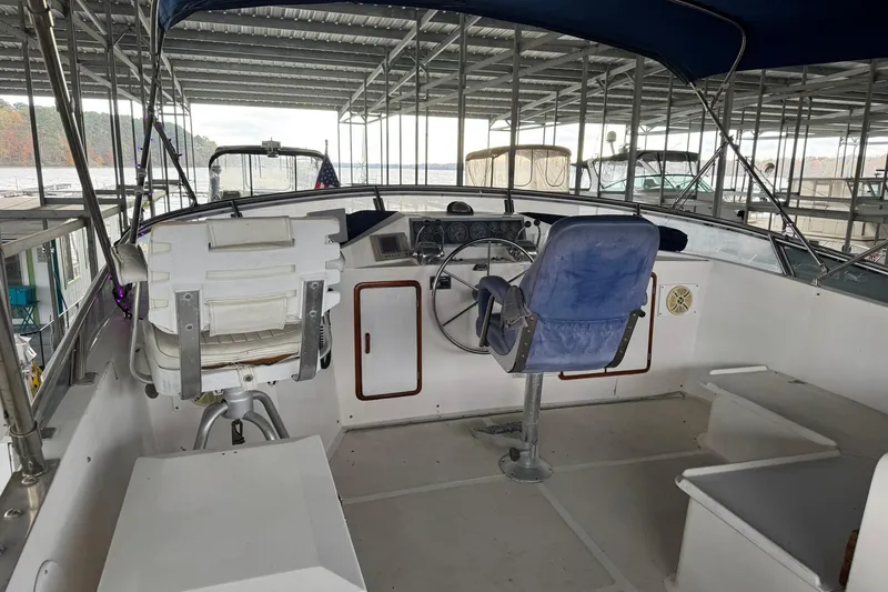Slide: The Image of 1991 DeFever 44 boat helm with dual seats under covered dock. - 17