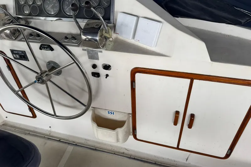 Slide: The Image of 1991 DeFever 44 yacht helm with steering wheel, gauges, and wooden cabinet. - 20
