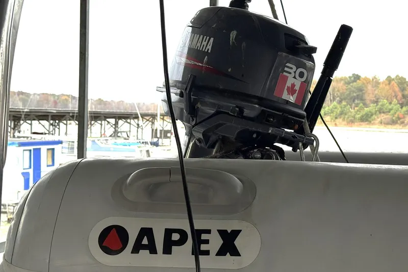 Slide: The Image of Apex inflatable boat with Yamaha 30 outboard motor, docked near a marina. - 24