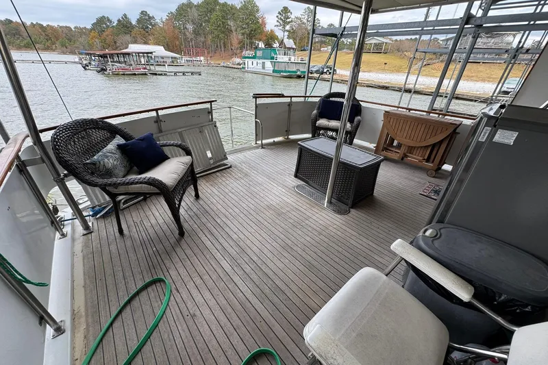 Slide: The Image of Spacious deck of 1991 DeFever 44 yacht with wicker seating and scenic marina view. - 32