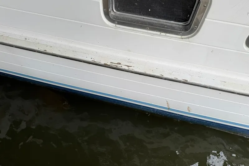 Slide: The Image of 1991 DeFever 44 boat hull with window, showing wear and waterline. - 6
