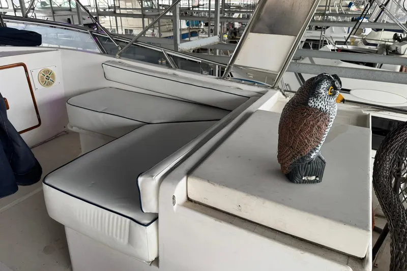 Slide: The Image of 1991 DeFever 44 yacht interior with cushioned seating and decorative owl statue. - 70
