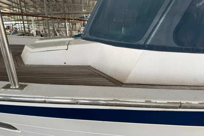 Slide: The Image of 1991 DeFever 44 yacht deck with wooden flooring and blue-tinted windows. - 9