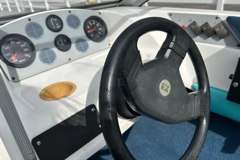 Slide: The Image of 1993 Larson All American 160 boat dashboard with steering wheel and gauges. - 6