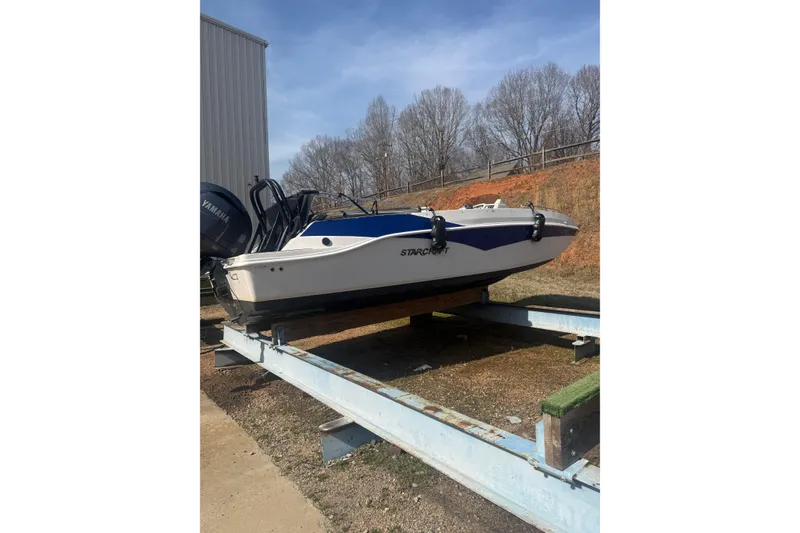 The Image of 2025 Starcraft SVX 211 OB boat on trailer, outdoors, with Yamaha engine. - 0