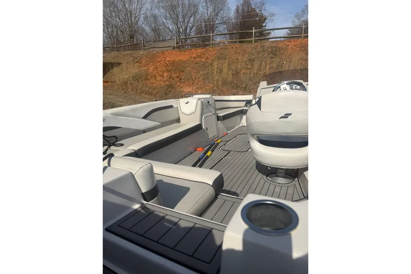 Slide: The Image of 2025 Starcraft SVX 211 OB boat interior with seating and steering wheel, outdoors. - 6