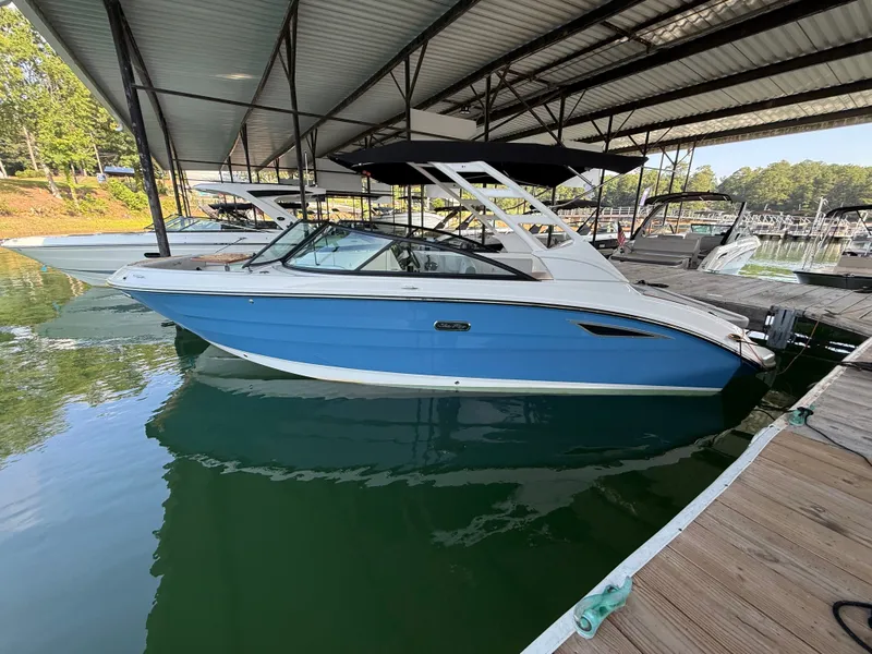 Slide: The Image of A blue and white 2026 Sea Ray SDX 250 is docked under a covered marina. - 1