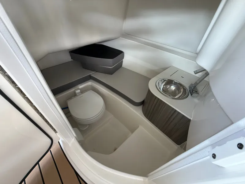 Slide: The Image of The image shows a compact boat cabin with a toilet, sink, and storage areas. - 10