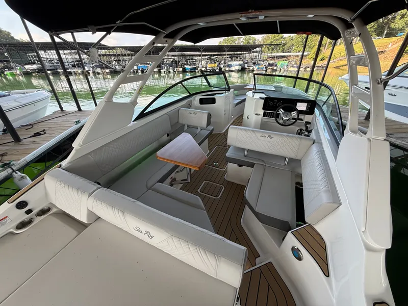 Slide: The Image of The image shows the cockpit of a Sea Ray SDX 250 boat. It features white upholstery and a wooden table. - 4