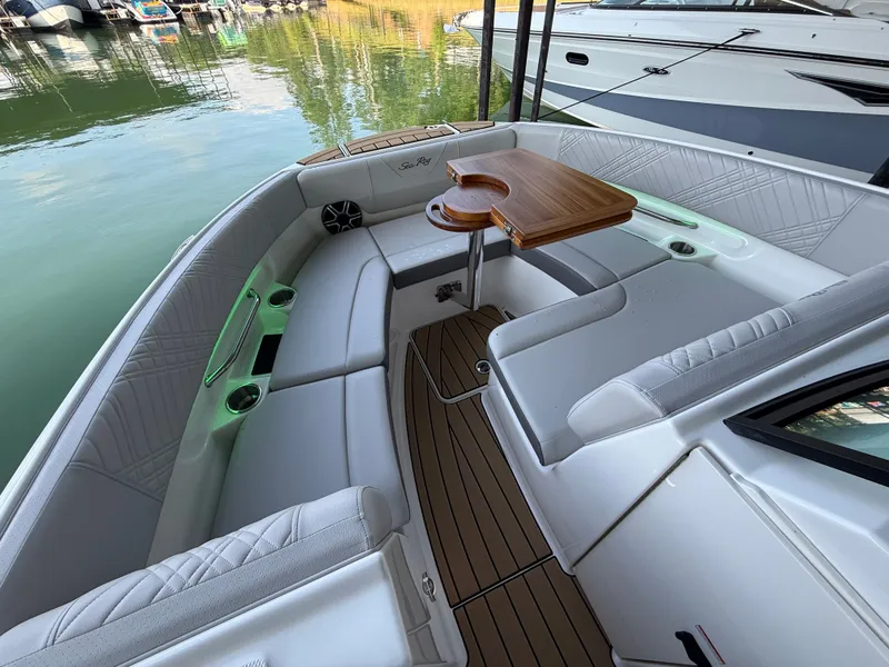 Slide: The Image of The image shows the cockpit of a 2026 Sea Ray SDX 250 with white upholstery and a wooden table. - 12