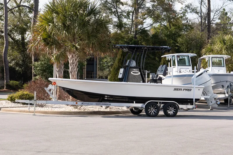 The Image of 2026 Sea Pro 230 Bay boat on trailer, parked near palm trees. - 1