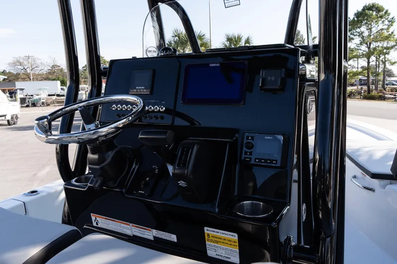 Slide: The Image of 2026 Sea Pro 230 Bay boat dashboard with steering wheel and electronic controls. - 15