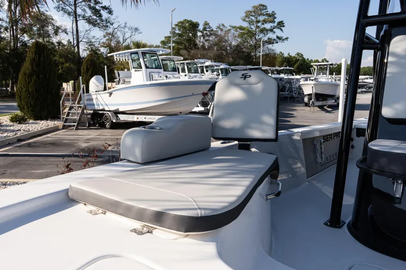 Slide: The Image of 2026 Sea Pro 230 Bay boat interior with seating, parked in a marina. - 18