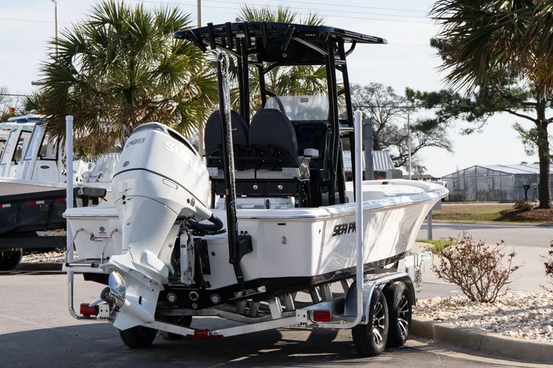 Slide: The Image of 2026 Sea Pro 230 Bay boat on trailer, parked outdoors with palm trees in background. - 6